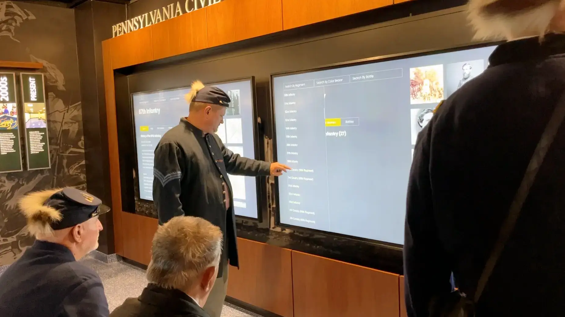 older man using flag list to find battles flag fought in on 98in planar touch screen